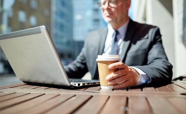 Senior businessman with laptop and coffee outdoors — Stock Photo, Image