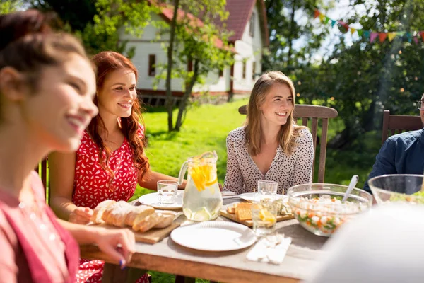 Glückliche Freunde beim Abendessen bei sommerlicher Gartenparty — Stockfoto