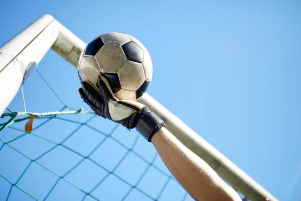 Воротар з м'ячем на футбольному полі над небом — стокове фото