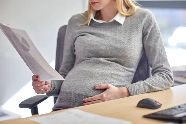 Femme d'affaires enceinte lecture de documents au bureau — Photo