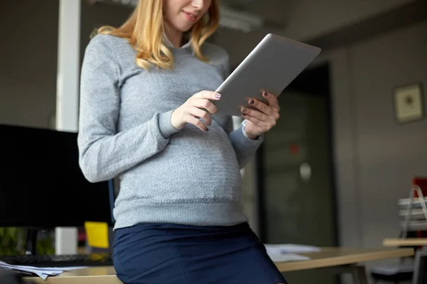 Femme d'affaires enceinte avec tablette PC au bureau — Photo