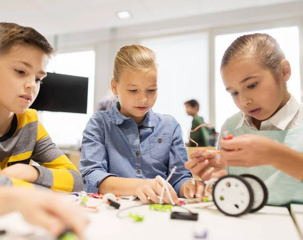 Счастливые дети строят роботов в школе робототехники — стоковое фото