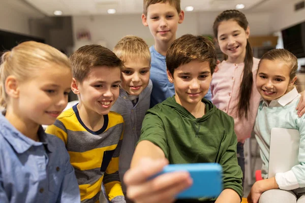 Grupp av skolbarnen tar selfie med smartphone — Stockfoto