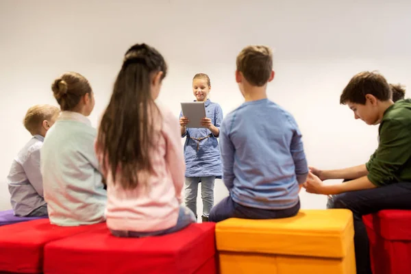 group of happy children with tablet pc at school