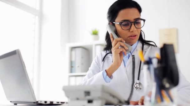 Arzt mit Papieren telefoniert im Krankenhaus — Stockvideo