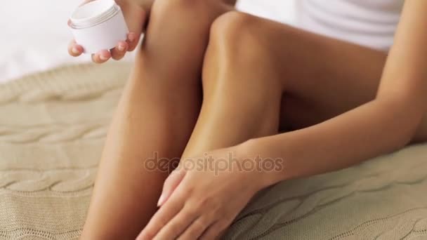 Mooie vrouw crème op haar benen thuis toe te passen — Stockvideo