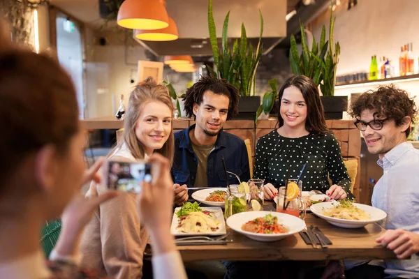 Friends with smartphone fotographing at restaurant — Stock Photo, Image