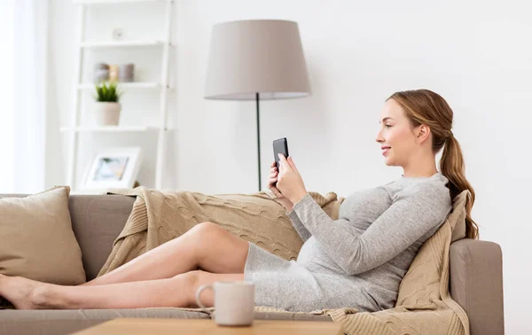 Wanita hamil bahagia dengan tablet pc di rumah — Stok Foto