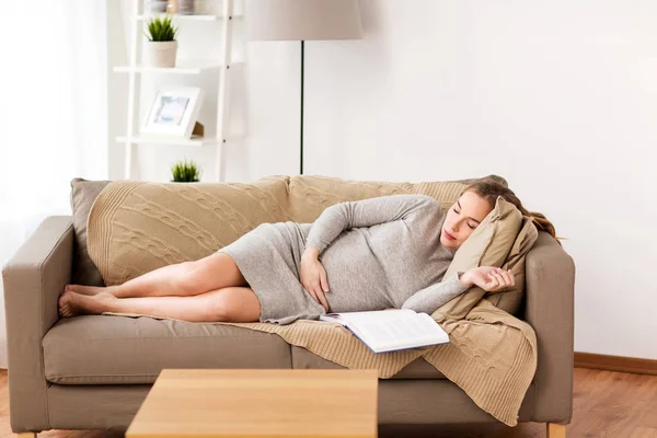 Mujer embarazada feliz durmiendo en el sofá en casa — Foto de Stock