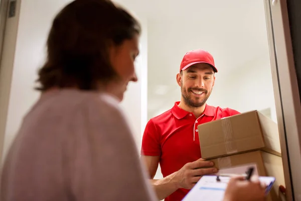 Deliveryman és a vevő a csomagküldő dobozok otthon — Stock Fotó