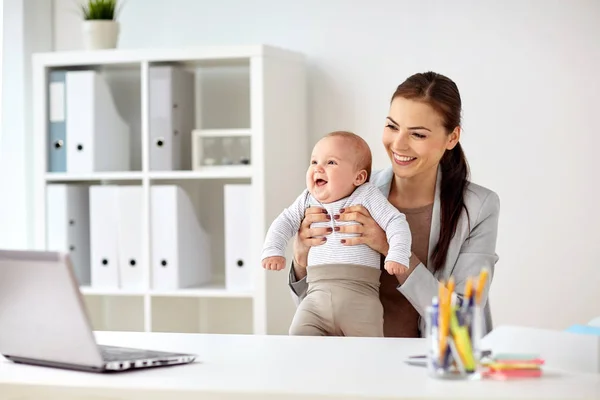 Gelukkig zakenvrouw met baby werken op kantoor — Stockfoto