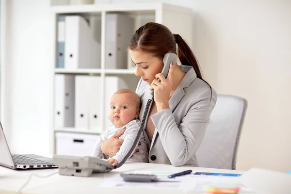 Affärskvinna med baby ringa på telefon på kontoret — Stockfoto