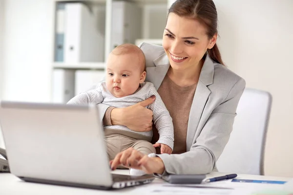 Femme d'affaires heureuse avec bébé et ordinateur portable au bureau — Photo