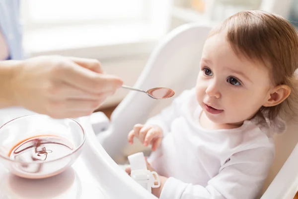 Mother feeding baby with puree at home — Stock Photo, Image