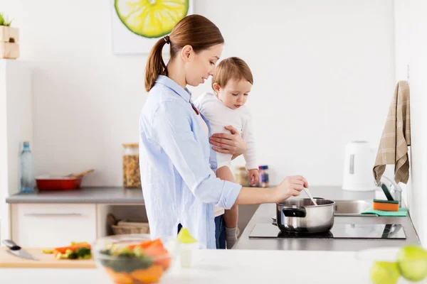 Feliz madre y bebé cocinando en casa cocina — Foto de Stock