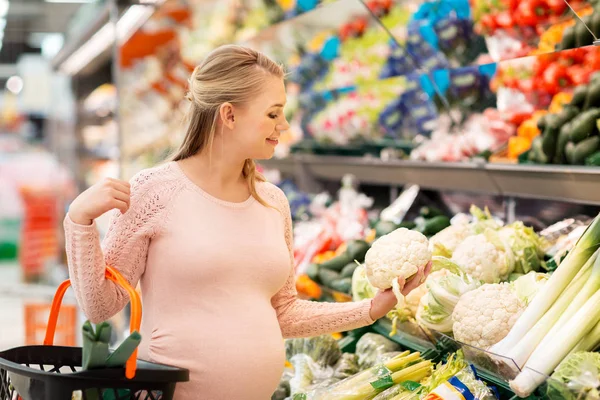 Heureux femme enceinte acheter chou-fleur à l'épicerie — Photo