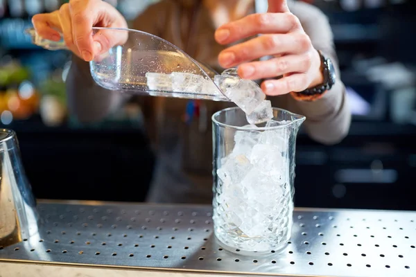 Barista versando ghiaccio nella brocca di vetro al bar — Foto Stock