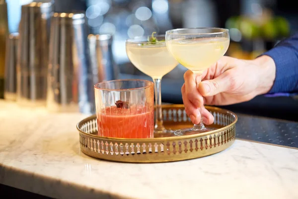 Barman met glazen cocktails in bar — Stockfoto