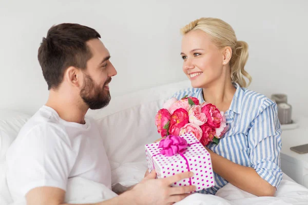 Mutlu çift yatakta evde hediye kutusu ile — Stok fotoğraf