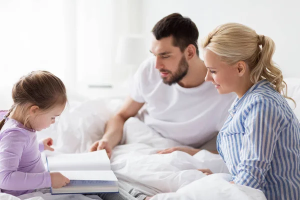 Szczęśliwego rodzinnego czytania książki w łóżku w domu — Zdjęcie stockowe