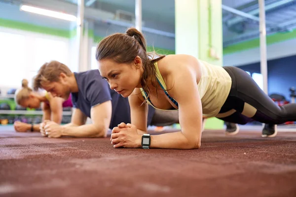 Mujer con rastreador de frecuencia cardíaca haciendo ejercicio en el gimnasio — Foto de Stock