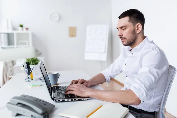 Zakenman typen op laptop op kantoor — Stockfoto