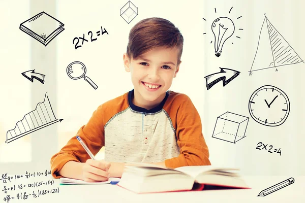 Leende student pojke skriva till anteckningsbok hemma — Stockfoto