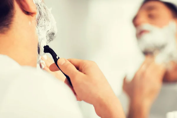 Primer plano del hombre afeitando la barba con cuchilla de afeitar — Foto de Stock