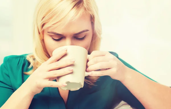 Щаслива жінка з чашкою чаю або кави вдома — стокове фото