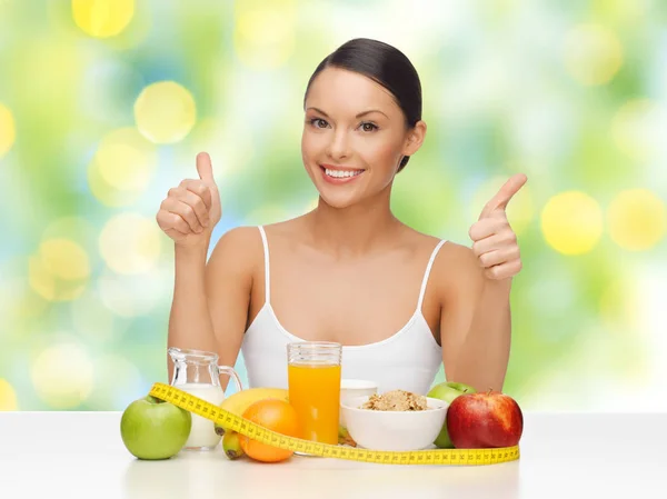 Frau mit Essen und Maßband zeigt Daumen hoch — Stockfoto