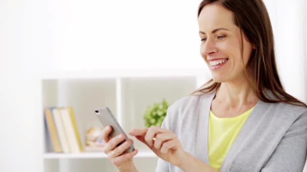 Happy woman texting message on smartphone at home — Stock Video