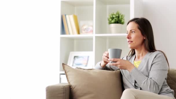 Gelukkige vrouw, drinken van thee of koffie thuis — Stockvideo