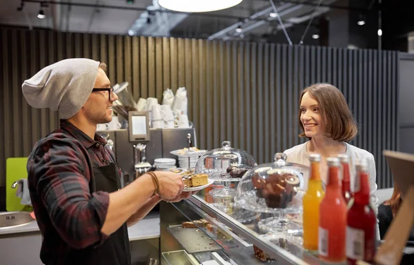 Homem ou barman com bolo servindo cliente no café — Fotografia de Stock