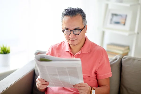 Homem feliz em óculos ler jornal em casa — Fotografia de Stock