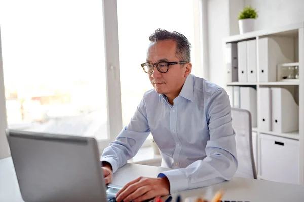 Businessman in eyeglasses with laptop office — Stock Photo, Image