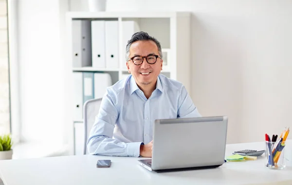 Glad affärsman i glasögon med laptop office — Stockfoto