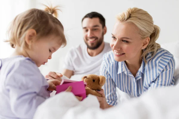 Mutlu aile ile evde yatakta hediye kutusu — Stok fotoğraf