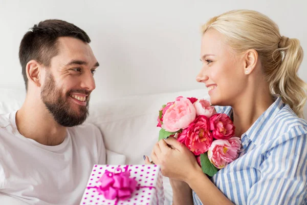 Mutlu çift yatakta evde hediye kutusu ile — Stok fotoğraf