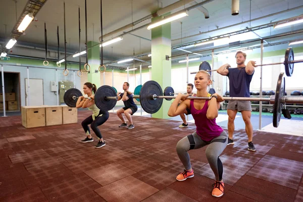 Träningsgrupp med skivstång och vikter på gym — Stockfoto