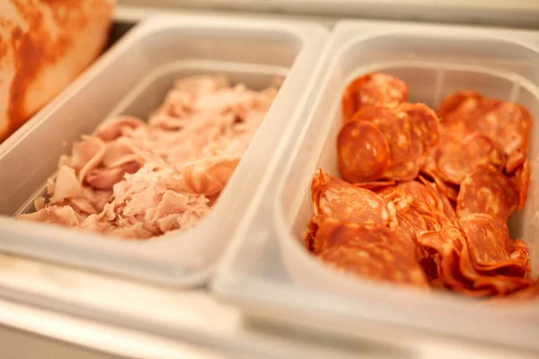 Containers with ham and salami at restaurant — Stock Photo, Image