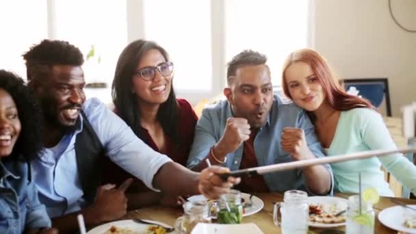 Друзья едят и делают селфи в ресторане — стоковое видео