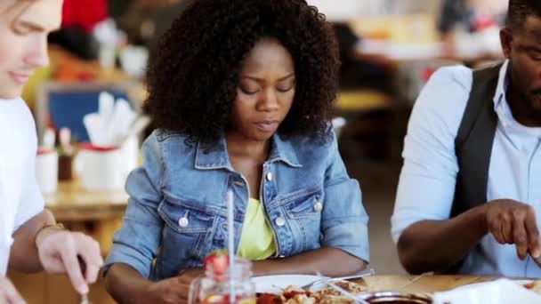 Счастливые друзья едят и пьют в ресторане — стоковое видео