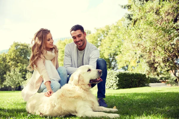 Feliz pareja con perro labrador paseando en la ciudad —  Fotos de Stock