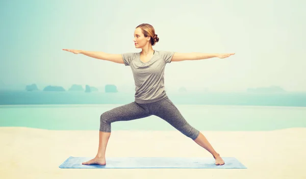 Frau lässt Yoga-Kriegerin auf Matte posieren — Stockfoto