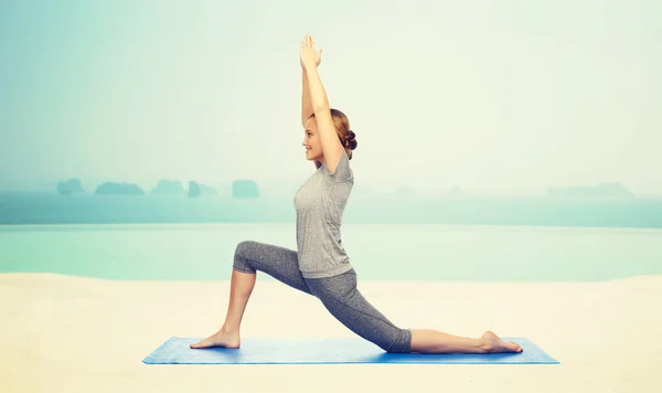 Glückliche Frau macht Yoga in niedrigem Ausfallschritt auf Matte — Stockfoto