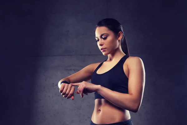 Jeune femme avec montre de fréquence cardiaque dans la salle de gym — Photo