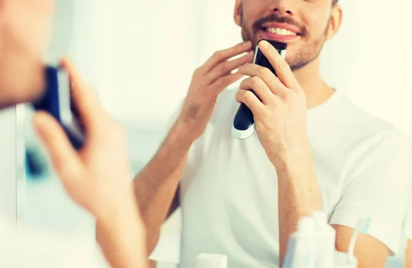 Primer plano del hombre afeitando la barba con trimmer —  Fotos de Stock