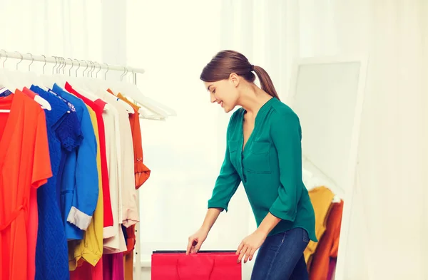 Mujer feliz con bolsas de compras y ropa en casa —  Fotos de Stock