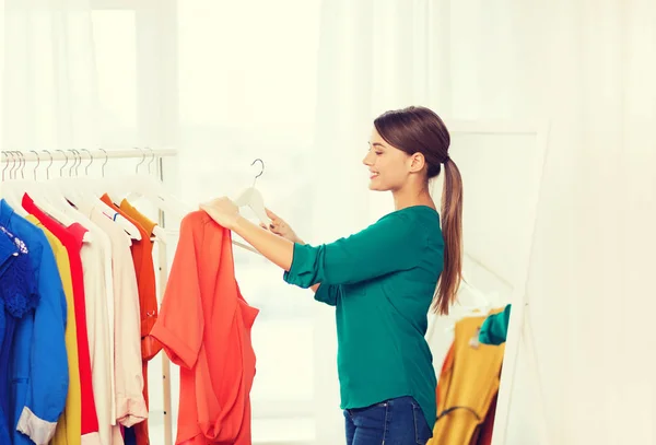 Mujer feliz eligiendo ropa en el armario de casa — Foto de Stock