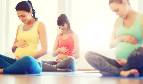Šťastné těhotné ženy cvičení jógy v tělocvičně — Stock fotografie
